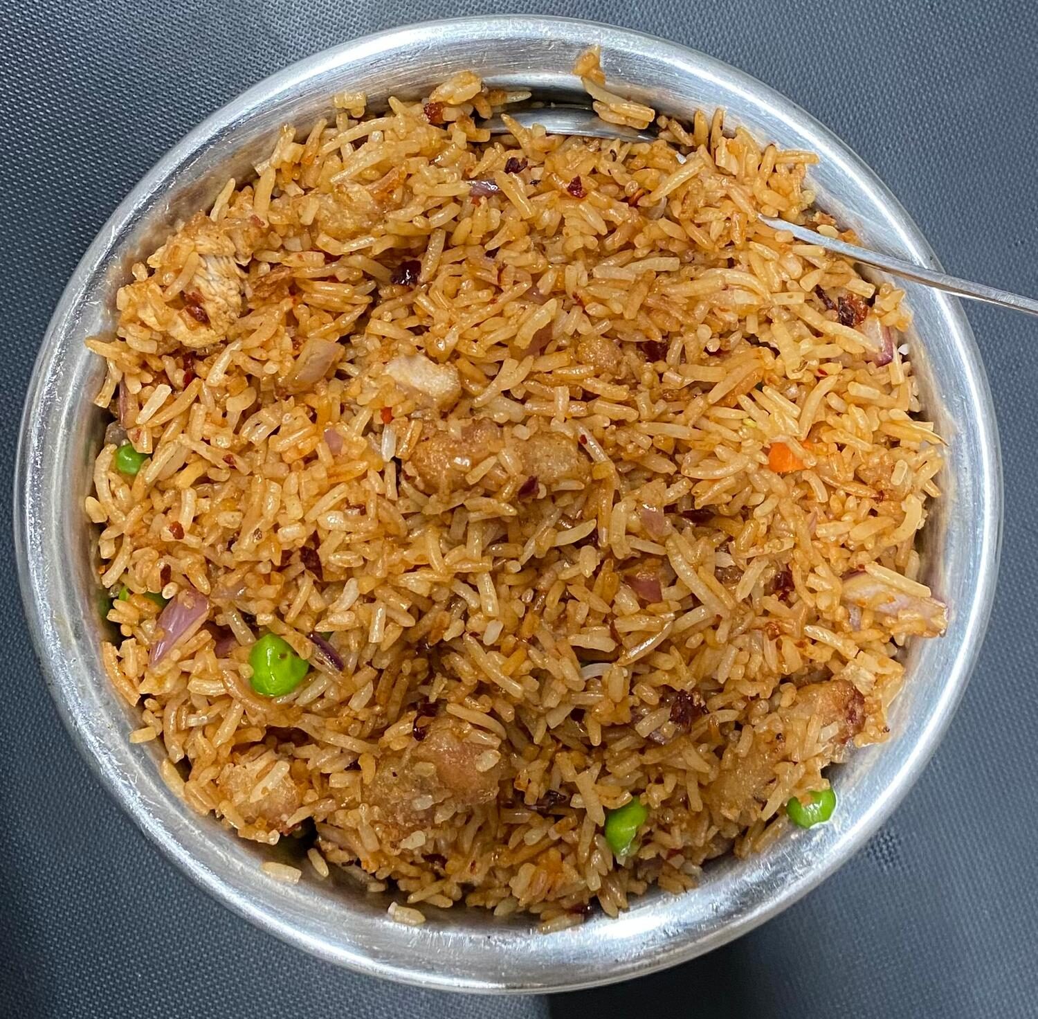 Schezwan chicken fried rice with peas and onions
